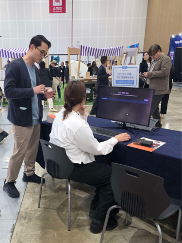 2025 제7회 충북 창업페스티벌'을 찾은 한 참관객이 비하이브컴퍼니 부스에서 AI 검색광고 자동화 솔루션 'liveAD'를 직접 시연해보고 있다.