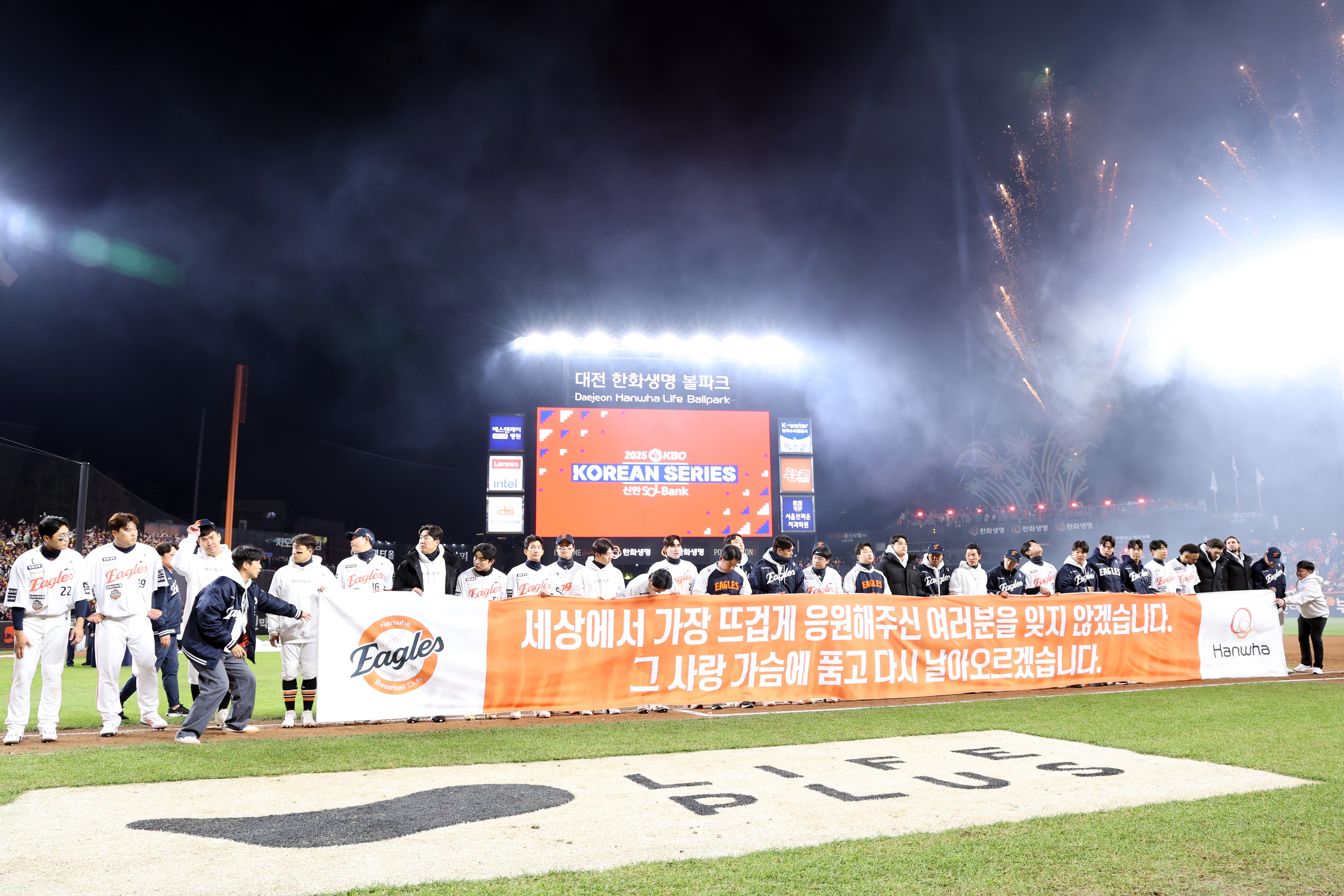 한화 이글스 선수들이 한국시리즈 준우승 직후 김승연 회장의 메시지가 담긴 현수막을 펼쳐 들고 팬들에게 감사 인사를 전하는 모습 (한화그룹 제공)