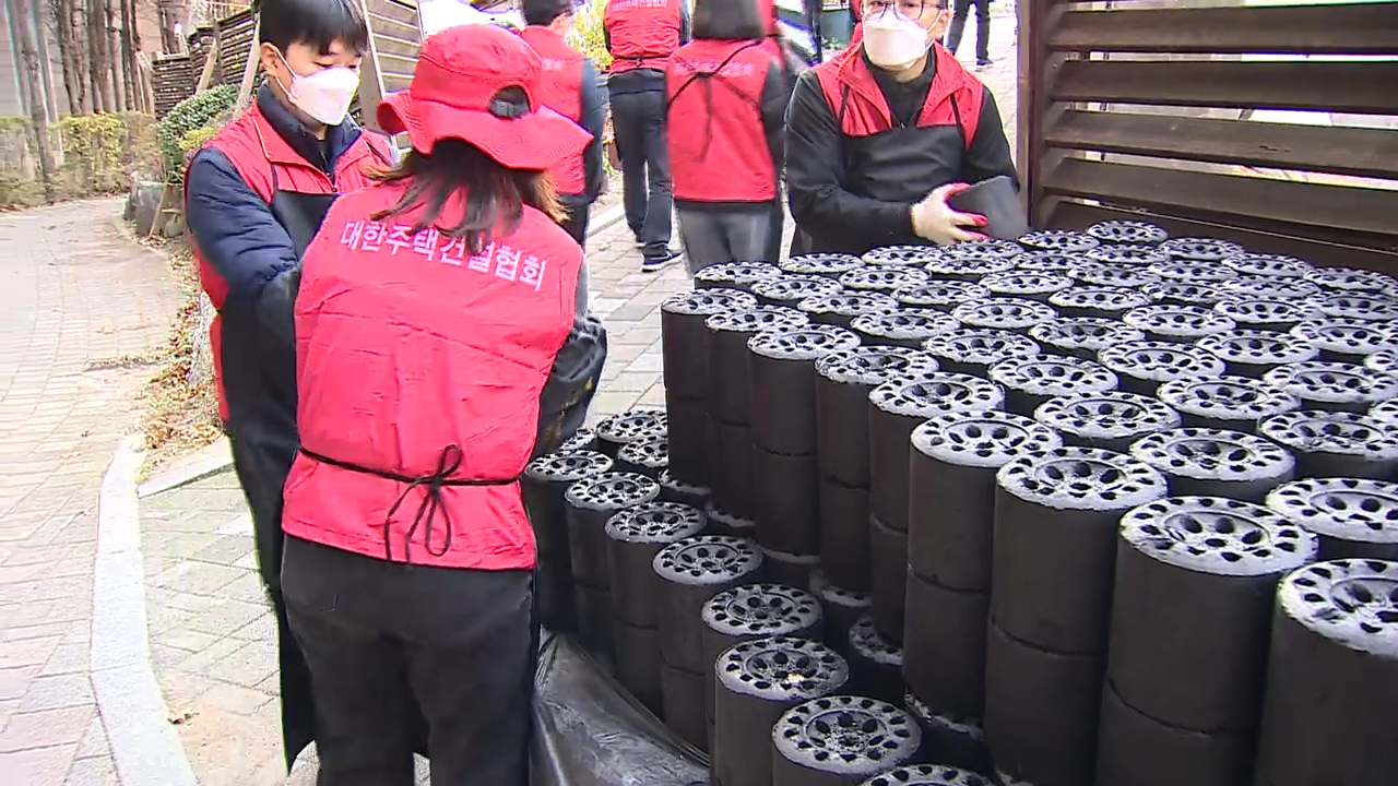 대한주택건설협회 임직원들이 동작구 일대에서 취약계층에 전달할 연탄을 나르고 있다.