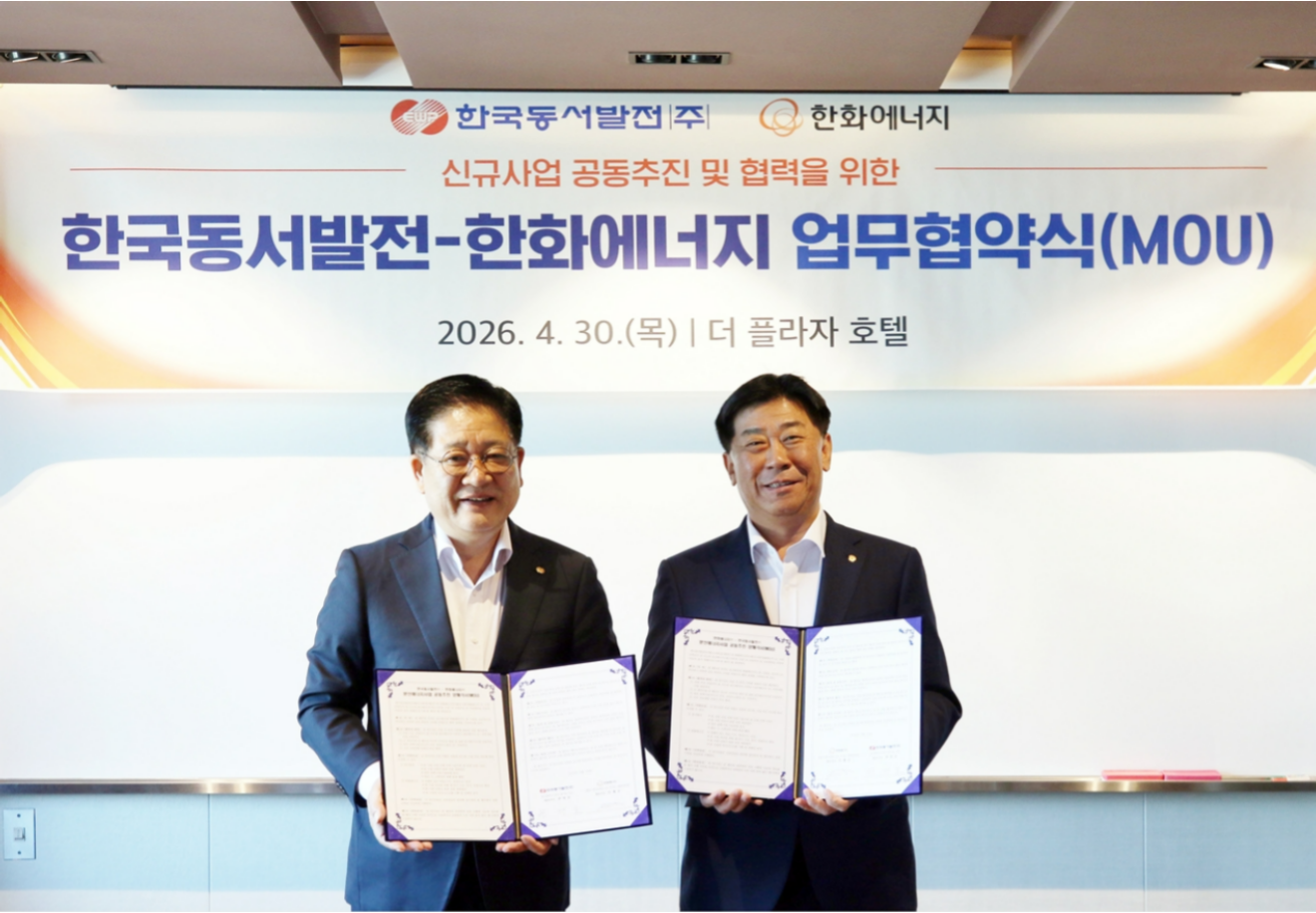권명호 사장과 이재규 한화에너지 대표이사가 분산에너지 사업 공동 추진 양해각서와 함께 기념촬영을 하고 있다.