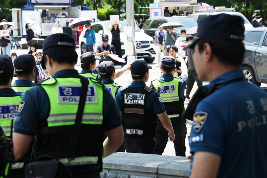 6·3 지방선거 투표용지 부족 사태를 규탄하며 재선거를 요구하는 ‘잠실 개표소 봉쇄 시위’가 계속되고 있는 지난 9일 서울 송파구 올림픽공원 핸드볼경기장 출입구 앞에서 경찰들이 교대하고 있다. 연합뉴스