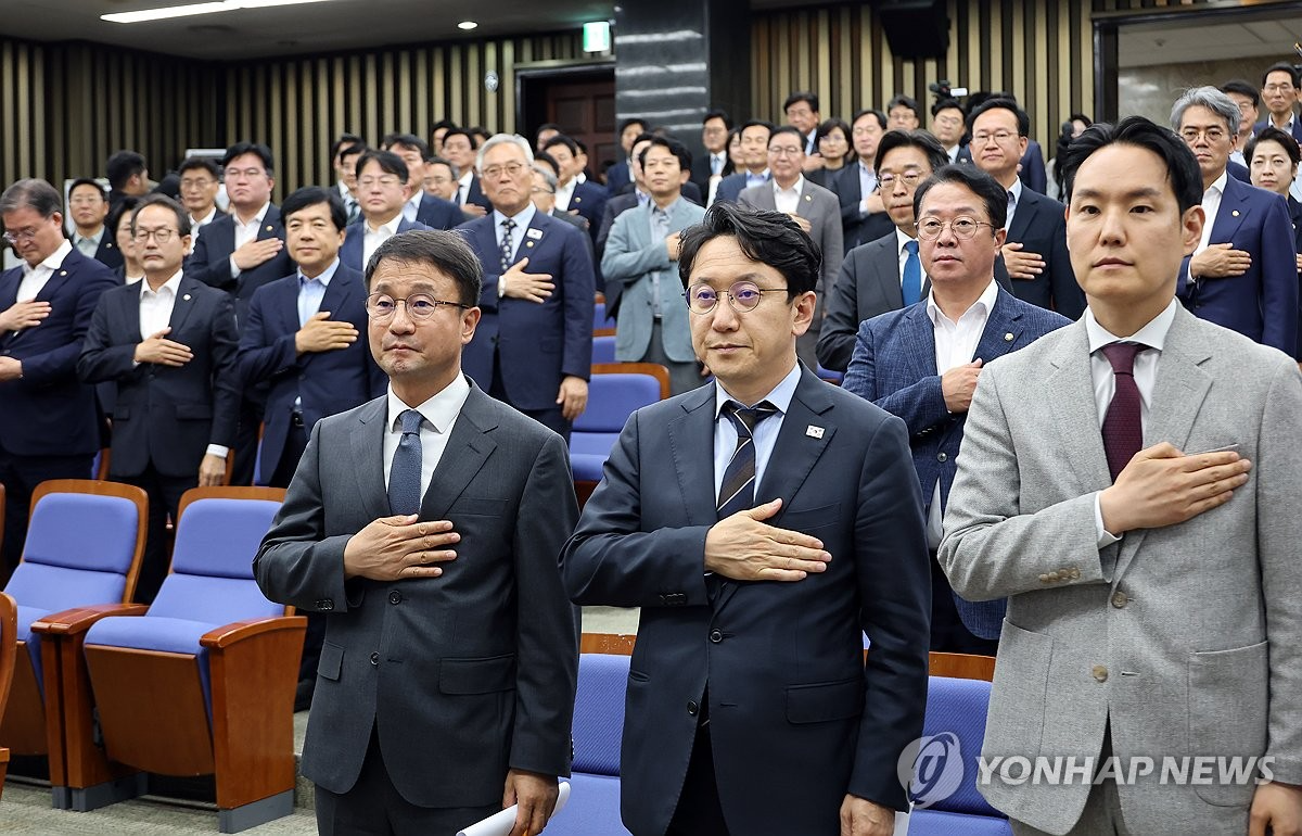 한병도 더불어민주당 원내대표(왼쪽)와 천준호 원내운영수석부대표를 비롯한 의원들이 30일 국회에서 본회의에 앞서 열린 의원총회에서 국기에 경례하고 있다. (사진=연합뉴스)