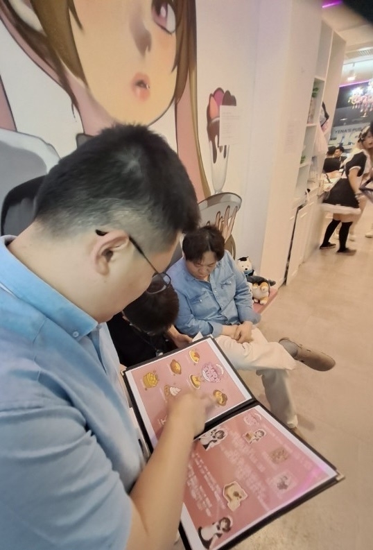 콘셉트카페에서 메뉴판을 확인하는 마포구 직원. 사진=마포구