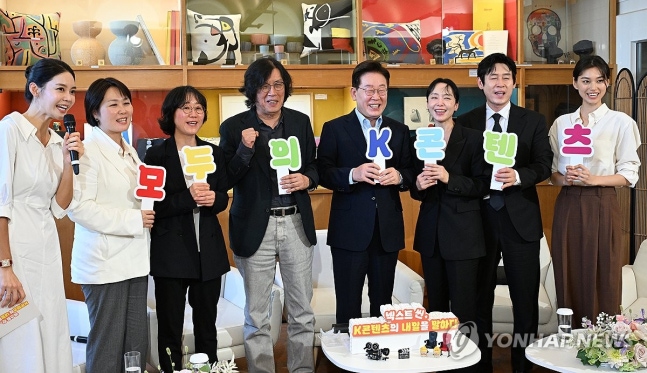 이재명 대통령이 7일(현지시간) 프랑스 남부 생폴드방스 마그 재단에서 국제 영화·영상 정상회의 '뤼미에르 서밋' 개막식 후 열린 영화인과의 대화에서 손팻말을 들고 기념촬영을 하고 있다(연합뉴스)