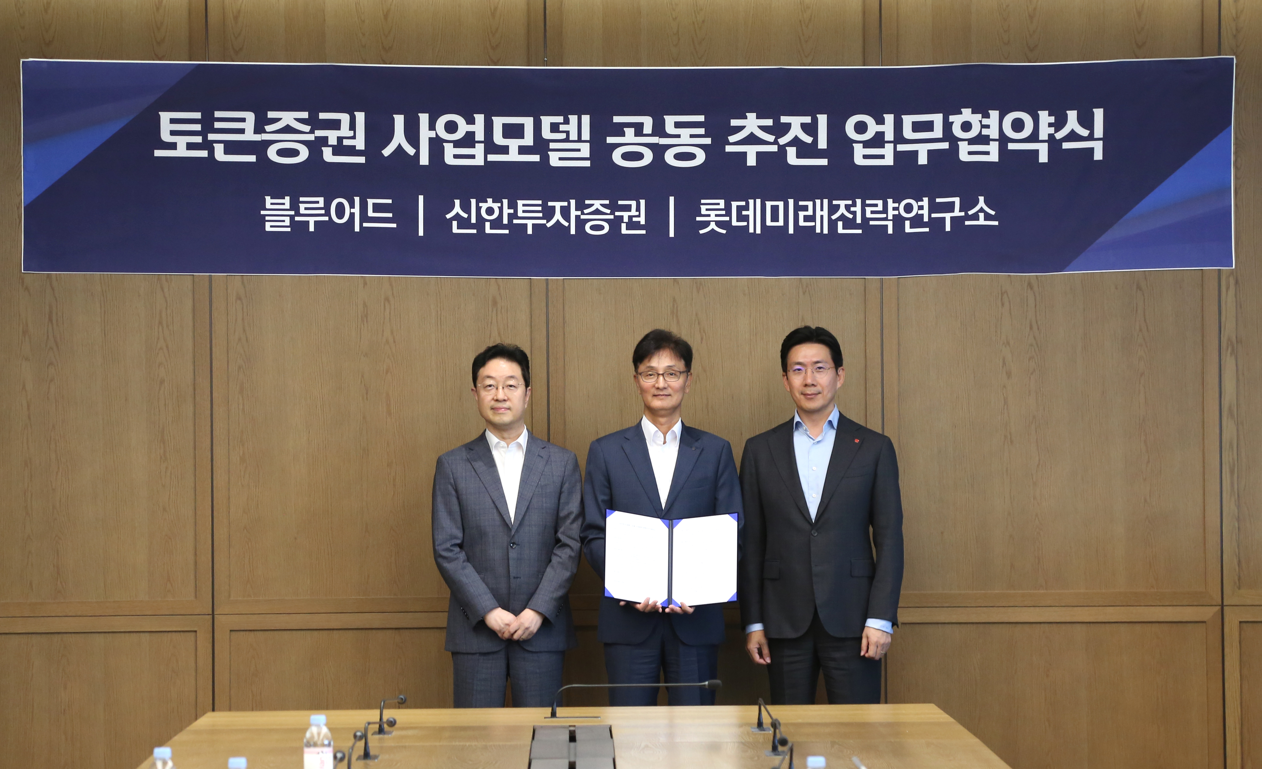 21일 신한투자증권 본사에서 열린 업무협약식에서 (왼쪽부터) 백만용 블루어드 금융부문 대표이사, 이선훈 신한투자증권 대표이사, 서창우 롯데미래전략연구소 대표이사가 기념촬영을 하고 있다.