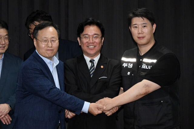 지난달 20일 경기 수원 경기고용노동청에서 열린 삼성전자 임금 협상을 마치고 (왼쪽)여명구 삼성전자 DS(디바이스솔루션·반도체 사업 담당) 피플팀장과 (오른쪽)최승호 삼성그룹 초기업노동조합 삼성전자지부 위원장이 잠정 합의안에 서명하고 김영훈 고용노동부 장관과 손을 맞잡고 기념 사진을 촬영하는 모습. (사진=연합뉴스)