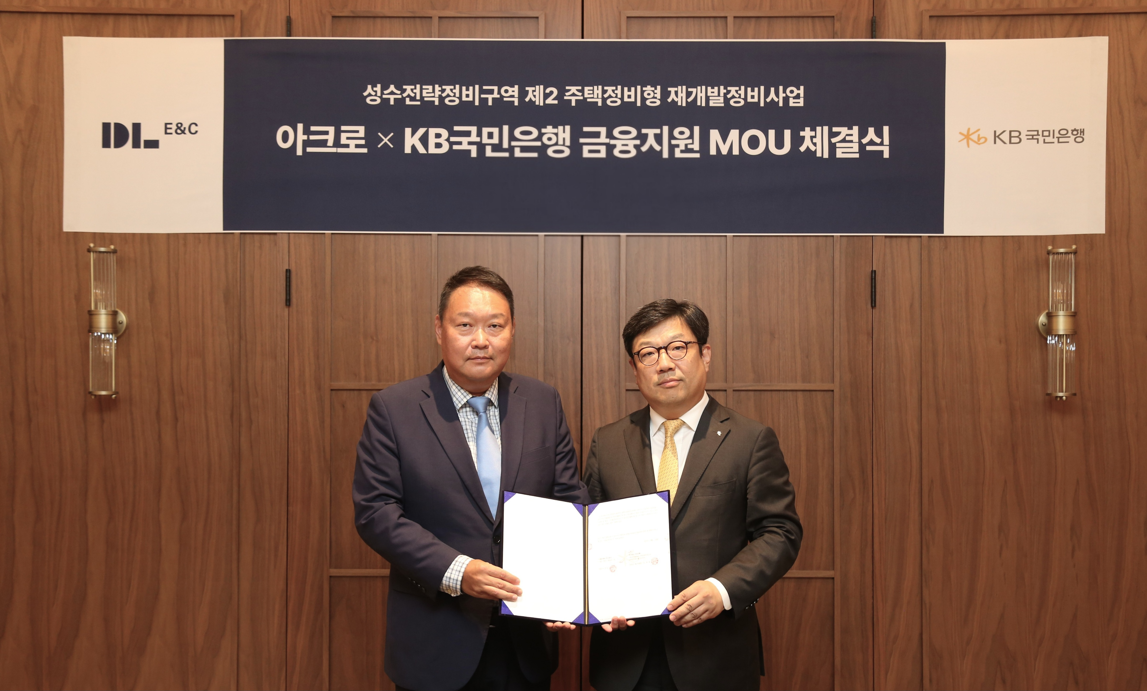 채준환 DL이앤씨 주택사업본부 도시정비사업 담당임원(왼쪽)이 이원종 KB국민은행 CIB영업그룹 부행장과 ‘성수2지구를 위한 하이엔드 금융 업무협약(MOU)’을 체결한 뒤 기념 촬영을 하고 있다.
