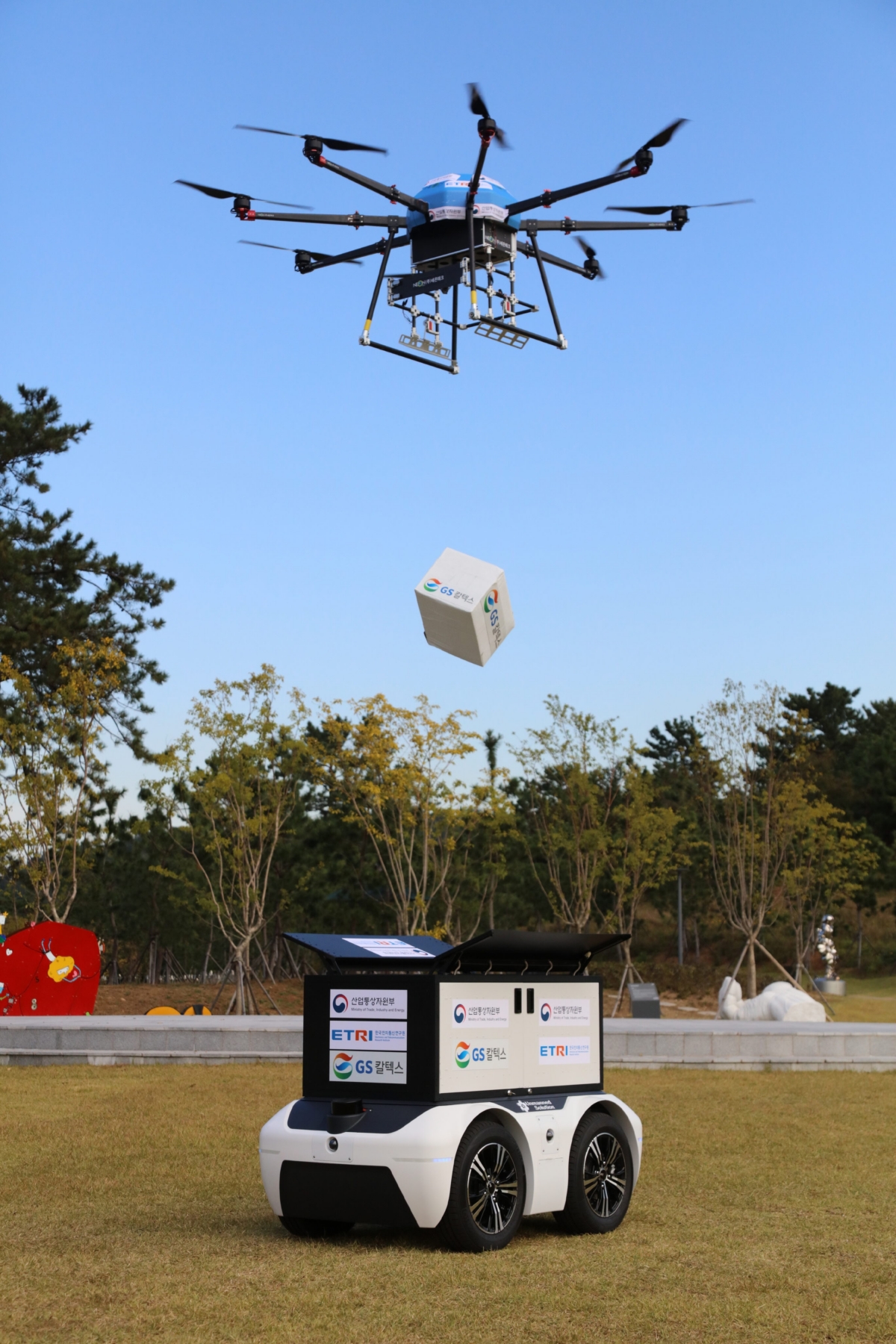 13일 여수 장도 잔디광장에서 드론이 상공에서 상품을 투하해 로봇에게 전달하고 있다.