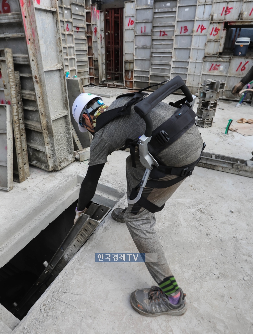 공사현장에서 한 근로자가 DL이앤씨의 근력-보조 웨어러블 슈트를 입고 작업하고 있다.