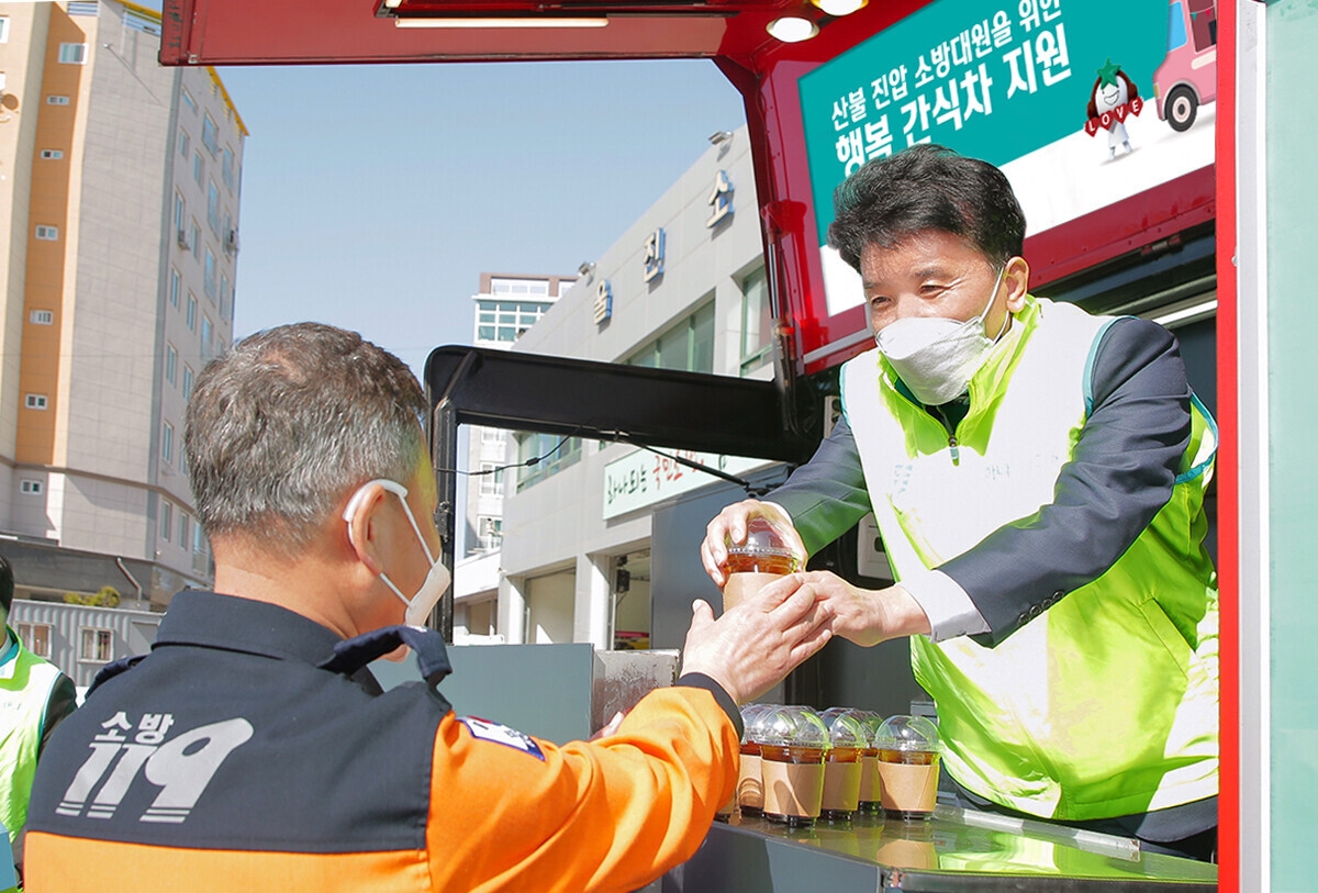 하나금융그룹 함영주 회장은 취임 후 첫 행보로 `동해안 산불 피해 지역 현장`을 방문했다. 함영주 회장(사진 오른쪽)이 울진소방서에 지원한 간식 차량에 직접 올라 타 소방대원에게 커피를 전달하고 있다.