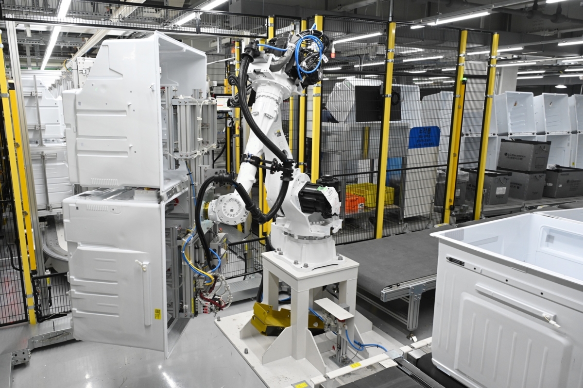 LG스마트파크 통합생산동 생산라인에 설치된 로봇팔이 무거운 냉장고 부품을 옮기는 모습 