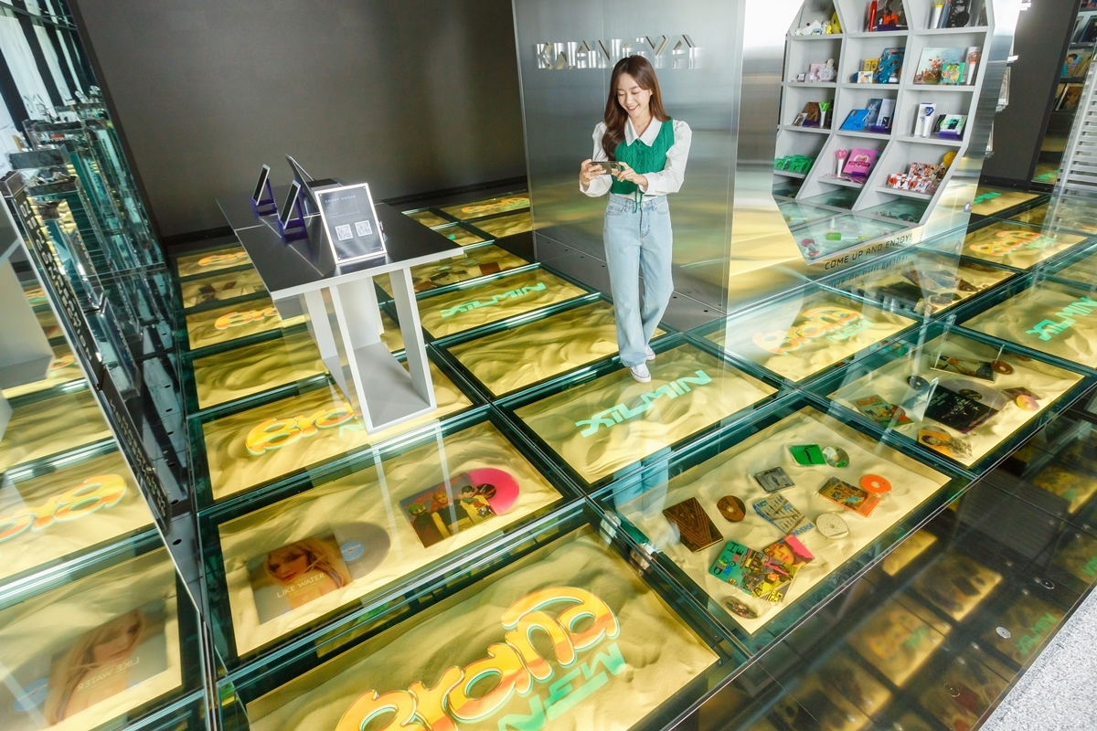 SM브랜드마케팅의 플래그십스토어 `광야@서울`을 방문한 고객이 LG디스플레이 투명 OLED 33대로 구성된 `투명 OLED 플로어 솔루션`을 경험하고 있다.