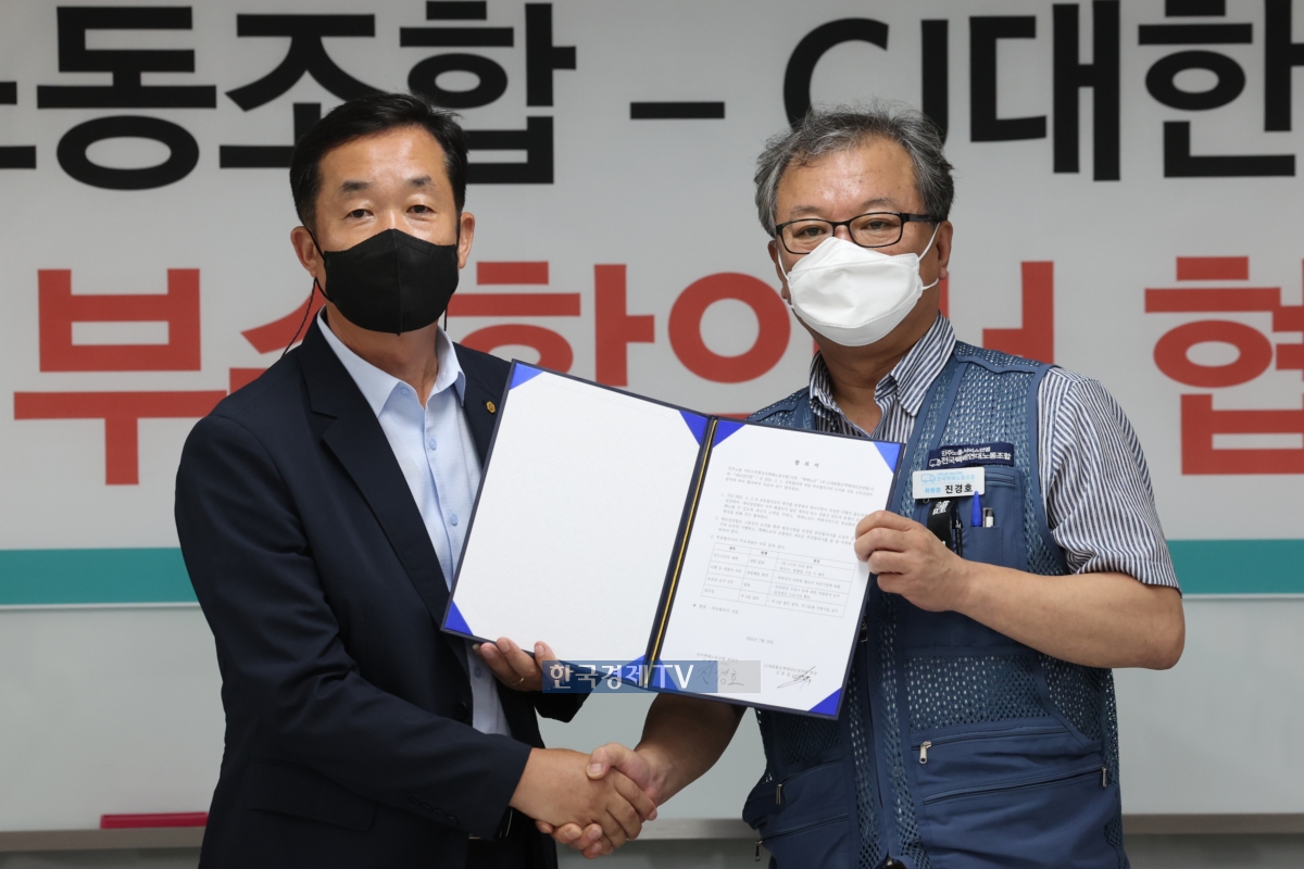 김종철 CJ대한통운대리점연합 회장(사진 좌측)이 지난해 3월 택배노조와 `표준계약서 부속 합의서`에 서명한 뒤 기념촬영을 하고 있다.