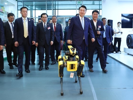 윤석열 대통령이 22일 베트남 하노이 국가컨벤션센터(NCC)에서 열린 한-베트남 파트너십 박람회에서 현대차 로봇 '스팟'의 안내를 받으며 이동하고 있다. 사진=연합뉴스