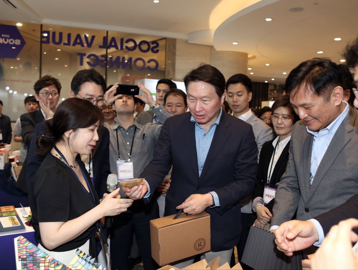 최태원(가운데) SK그룹 회장이 2019년 5월 서울 광진구 워커힐 호텔에서 열린 'SOVAC 2019' 행사장에서 소셜벤처 제품을 구매하고 있다.(SK제공)
