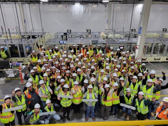 얼티엄셀즈 직원들이 제2공장에서 생산된 첫 파우치형 배터리를 들고 기념사진을 찍고 있다. LG에너지솔루션 제공