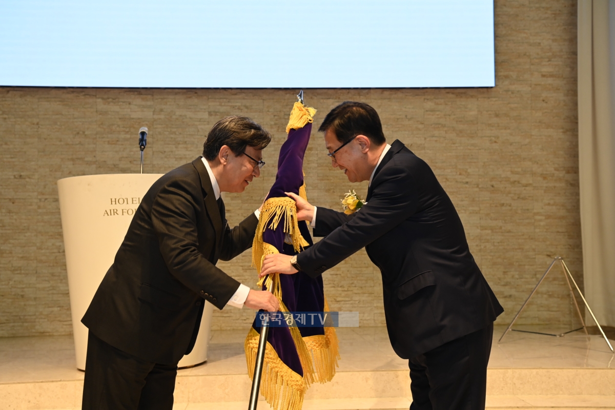 서영득 회장이 신임 최병채 회장에게 공군학사장교기를 전달하고 있다.