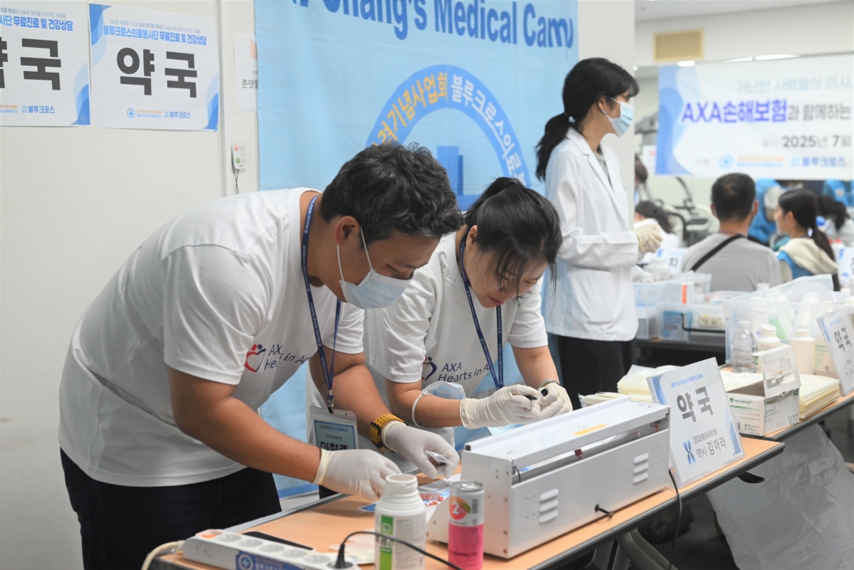 악사(AXA)손해보험 임직원들이 구립용산장애인복지관에 마련된 무료 진료소에서 약국 보조 활동을 하고 있다. 사진=악사손보)