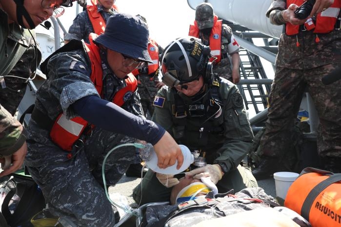 지난 21일 동해 해상에서 실시한 해군 1함대-국군대전병원 간 합동 의무 지원 훈련에서 이국종 국군대전병원장을 비롯한 전방 전개 외과팀이 현시학함에서 가상의 응급 환자에 대한 응급 조치를 하는 모습 (해군 및 국군대전병원 제공)