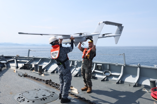 21일 동해 해상에서 실시한 해군 1함대-국군대전병원 간 합동 의무 지원 훈련에서 이국종 국군대전병원장을 비롯한 국군대전병원 드론팀과 현시학함 장병들이 드론을 활용해 환자 검체를 함대 의무대로 보내는 모습 (해군 및 국군대전병원 제공)